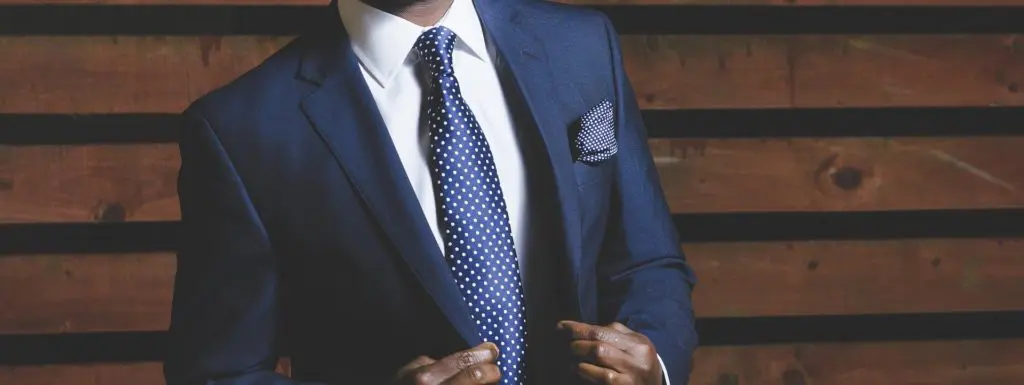 man in a suit and tie is adjusting his jacket