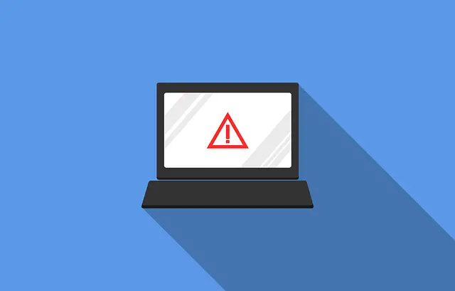 a laptop with a red warning sign on the screen
