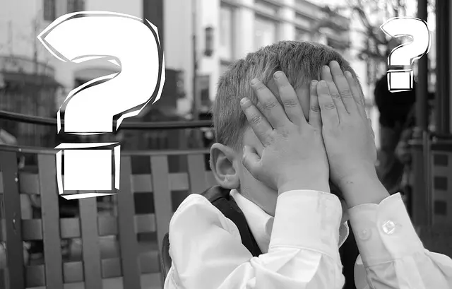 a young child holding their hands to their face and a question mark appearing next to them (the photo is in black and white)