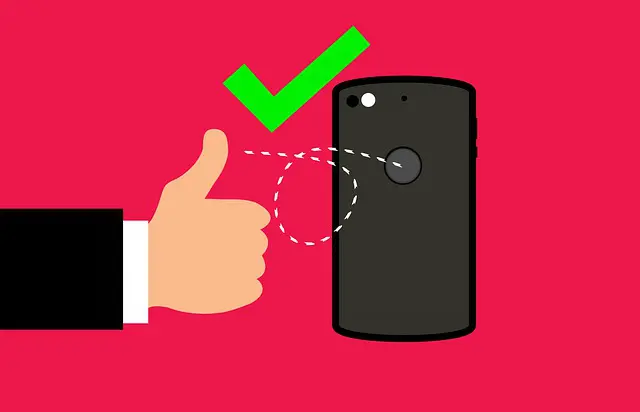 hand giving a thumbs up next to a cell phone