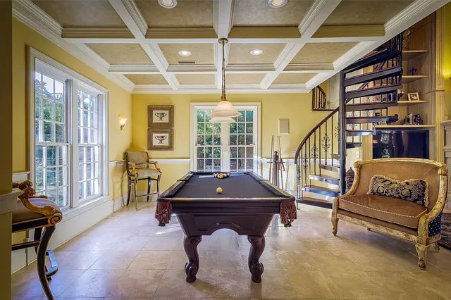 a pool table in a room with a spiral staircase