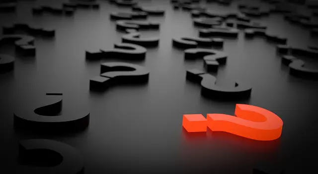 a red question mark is surrounded by black question marks
