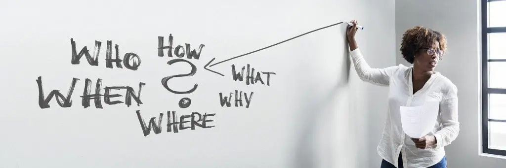 Woman writing on a whiteboard that says who how when what why where