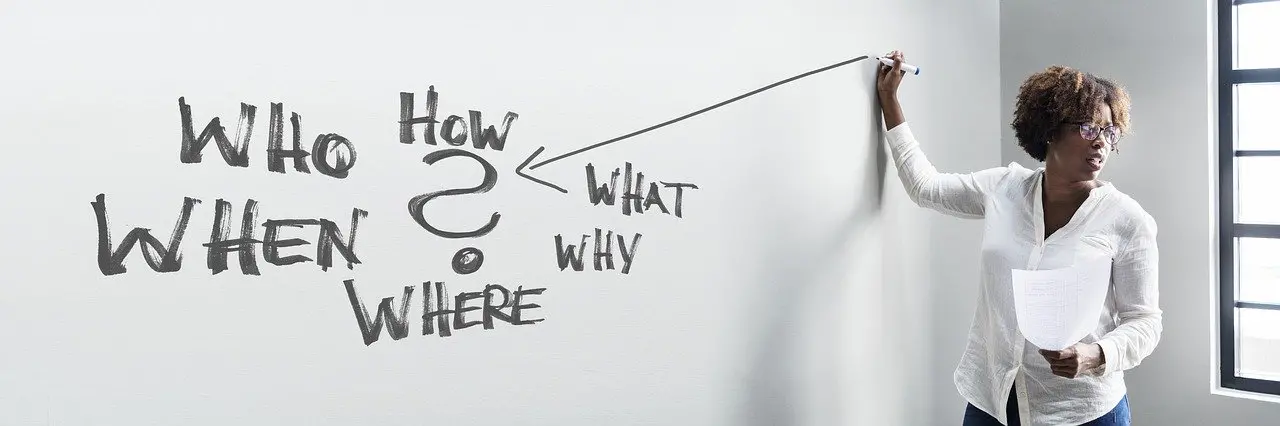Woman writing on a whiteboard that says who how when what why where