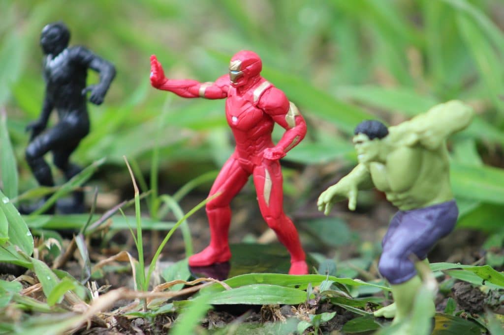 iron man and the hulk are standing in the grass