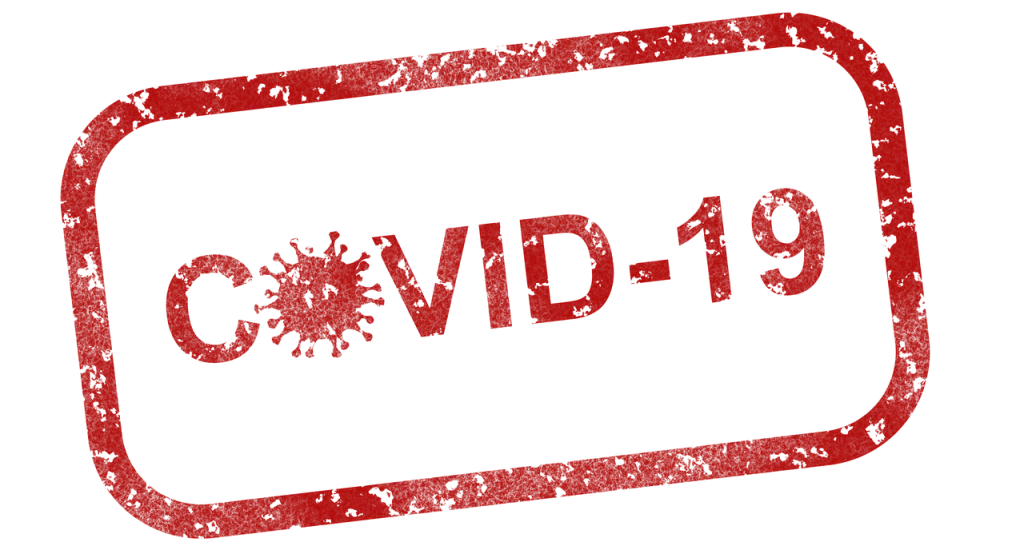 a red covid-19 stamp on a green background