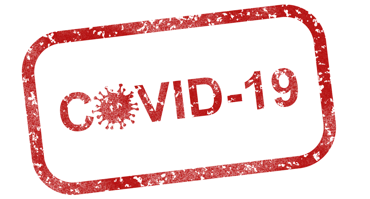 a red covid-19 stamp on a green background