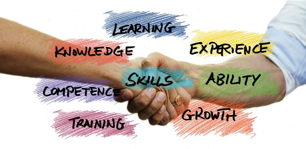 a handshake with the words learning experience skills competence training and growth written on it