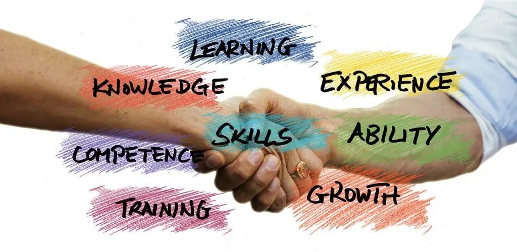 a handshake with the words learning experience skills competence training and growth written on it