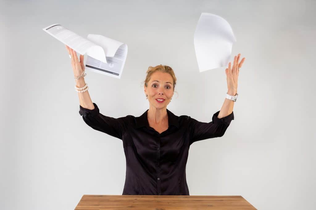 Woman in a black shirt throwing papers in the air
