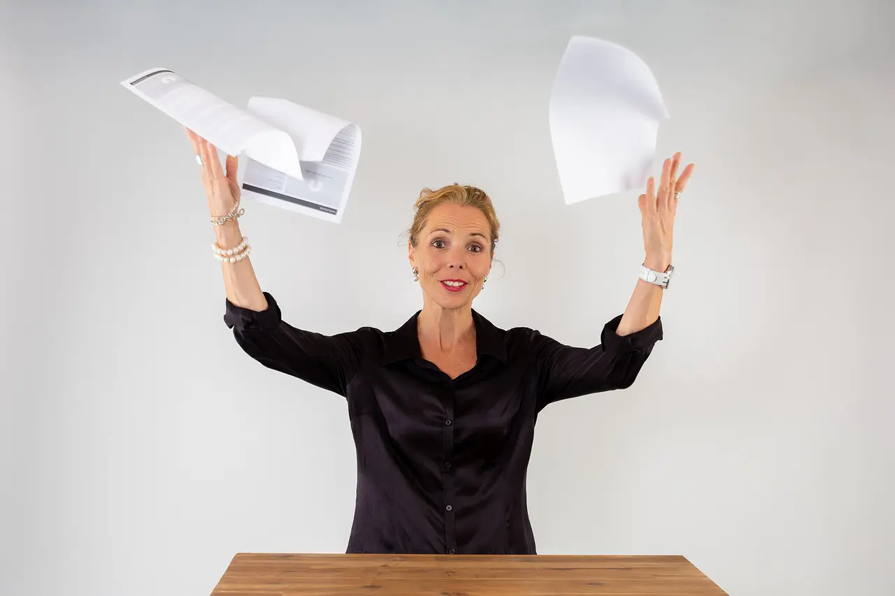Woman in a black shirt throwing papers in the air