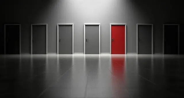 row of doors with one red door in the middle