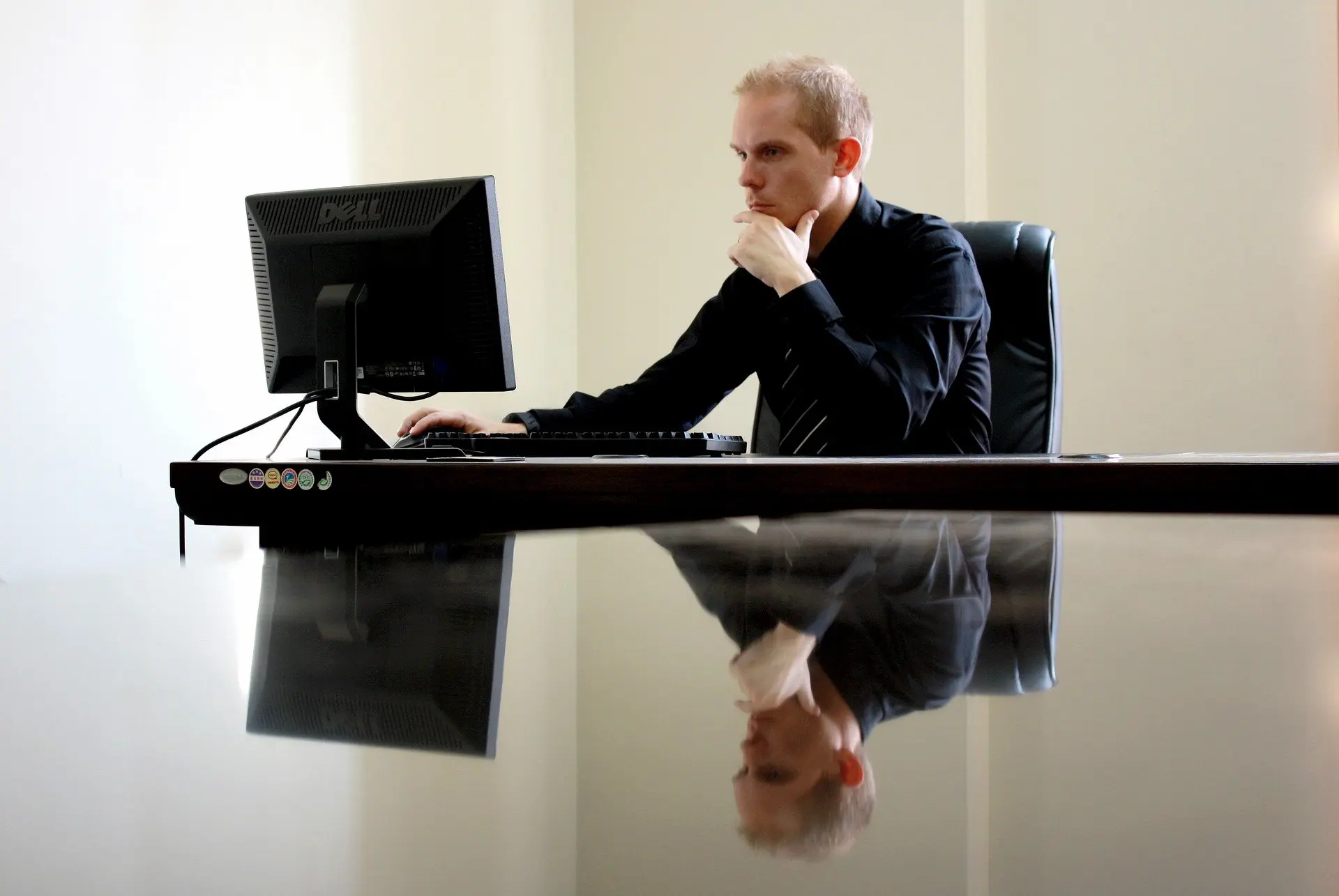 a man sits at a desk with a dell computer monitor