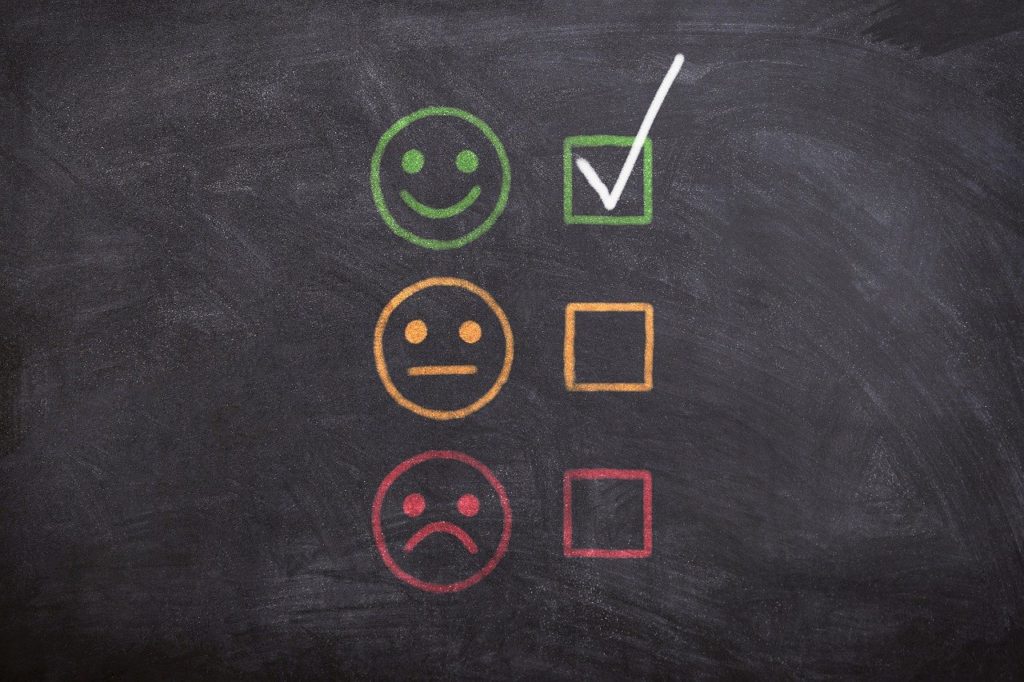 a blackboard with smiley faces and a check mark