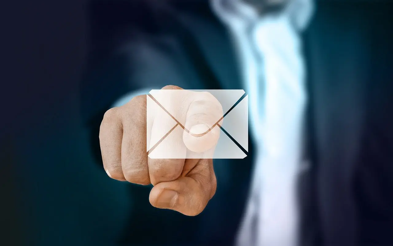 an individual dressed in a suit, pointing their finger towards the screen, clicking on an email icon
