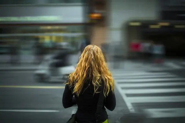 woman is walking across a crosswalk in a blurry photo