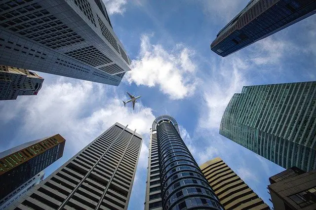 a plane is flying over a city of tall buildings .