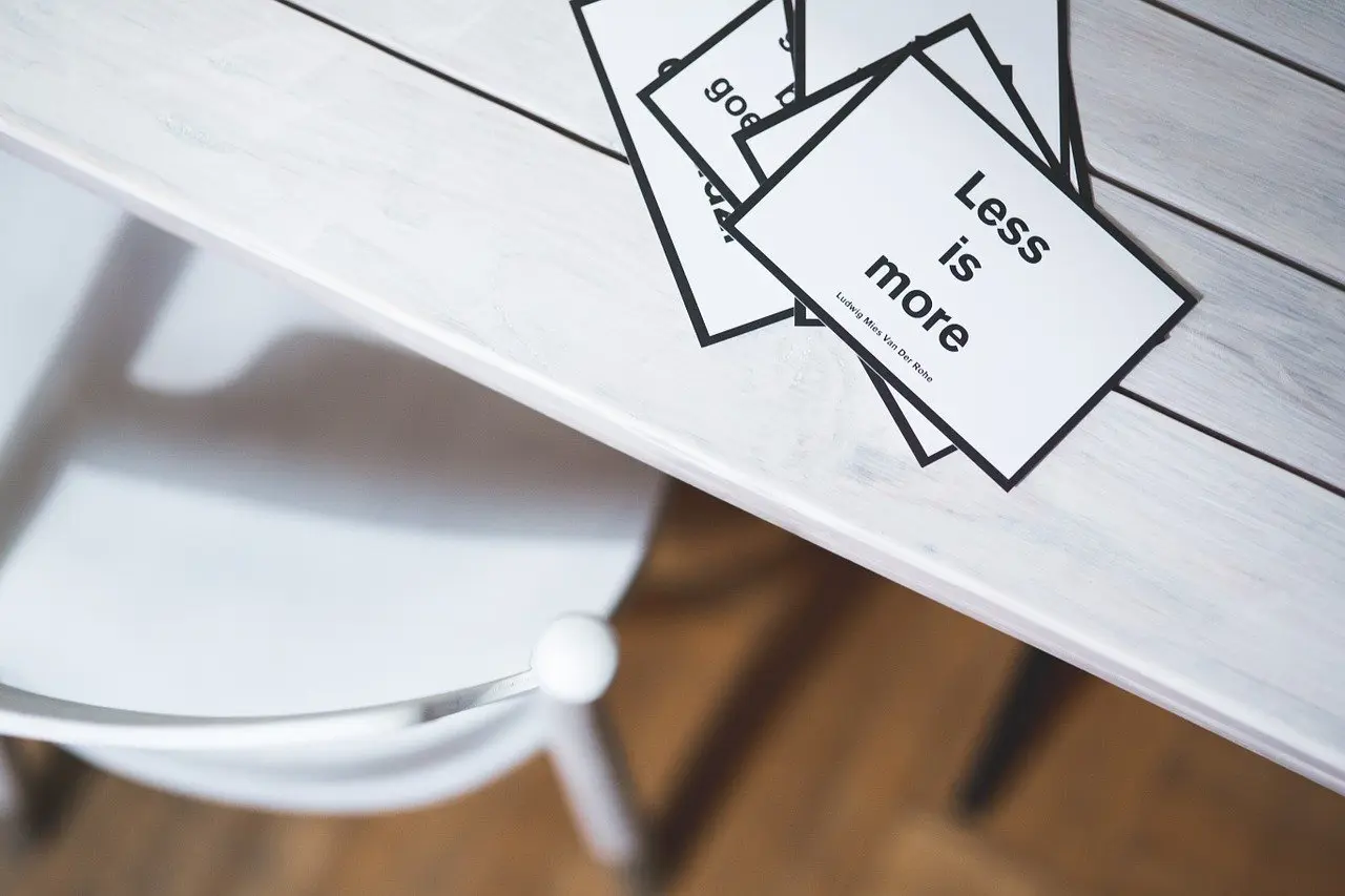 a stack of cards on a table that say less is more