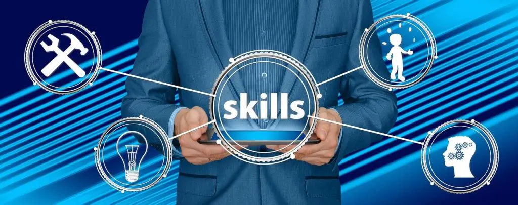 a man in a suit holds a tablet with the word skills on it