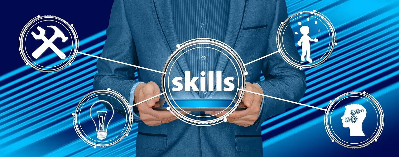 a man in a suit holds a tablet with the word skills on it