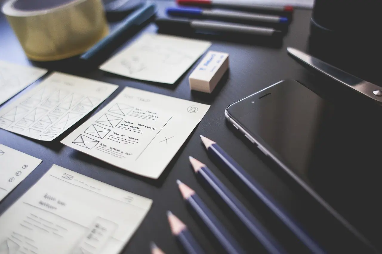 a cell phone sits on a desk next to pencils and a white eraser