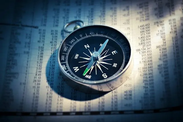 compass is sitting on top of a piece of paper with numbers on it