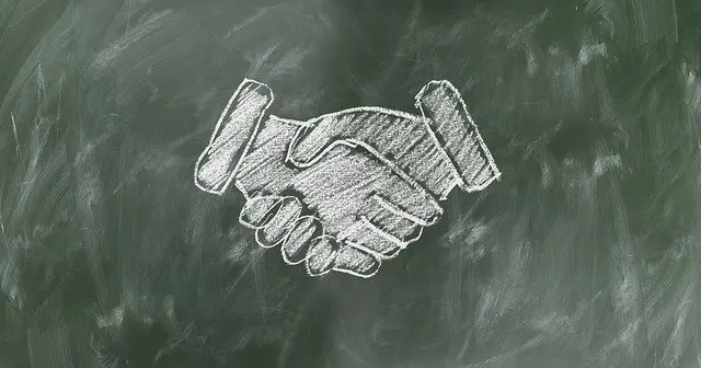 two hands drawn in chalk are shaking