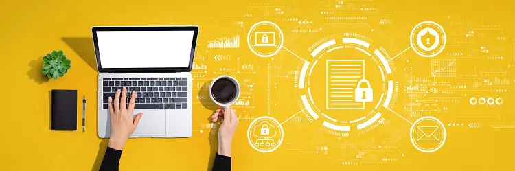 a person is using a laptop computer while holding a cup of coffee