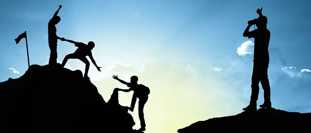 a group of people are helping each other climb a mountain
