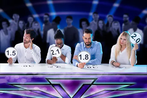 a group of people are sitting at a table holding score cards