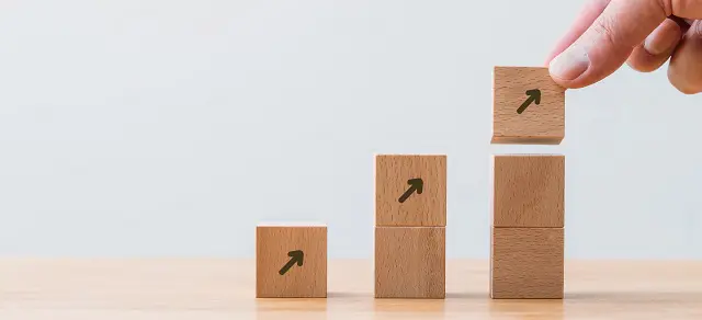 a person is stacking wooden blocks with arrows on them