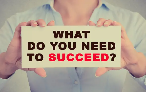woman is holding a sign that says what do you need to succeed