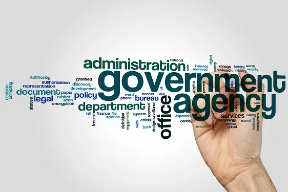 Hand pointing at government agency word cloud with key administrative terms