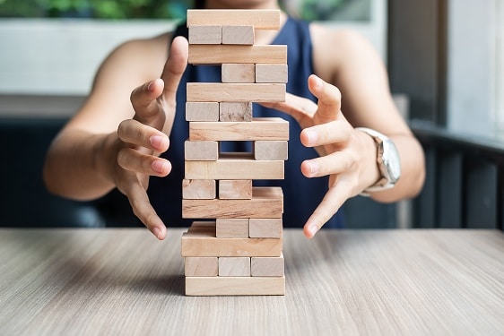 a person is stacking wooden blocks on top of each other
