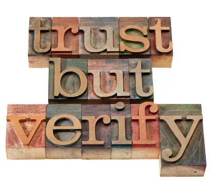 the words trust but verify are written in wooden letterpress type