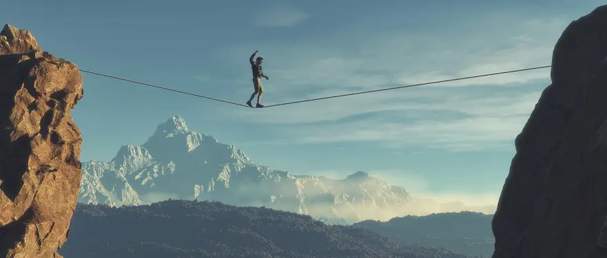a man is walking on a tightrope over a mountain
