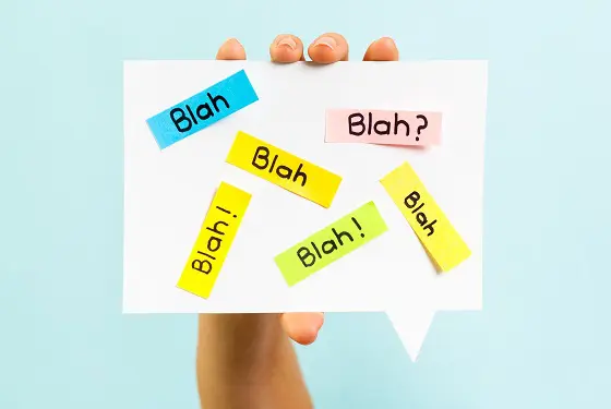 a hand is holding a piece of paper with blah written all over it