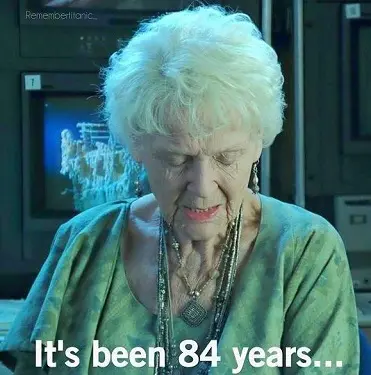 an elderly woman staring down with the text 'it's been 84 years...' displayed on screen