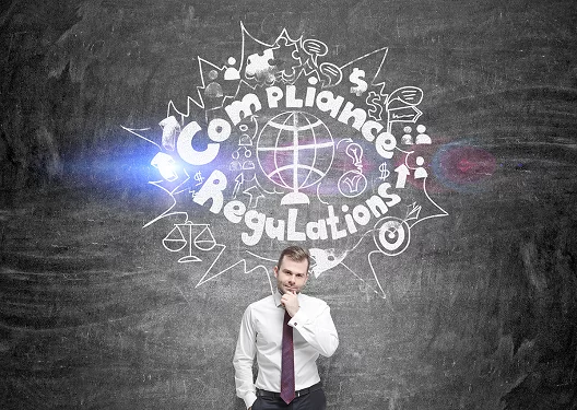 a man with his fingers on his chin, thinking, with the words 'compliance regulations' above his head surrounded by some doodles