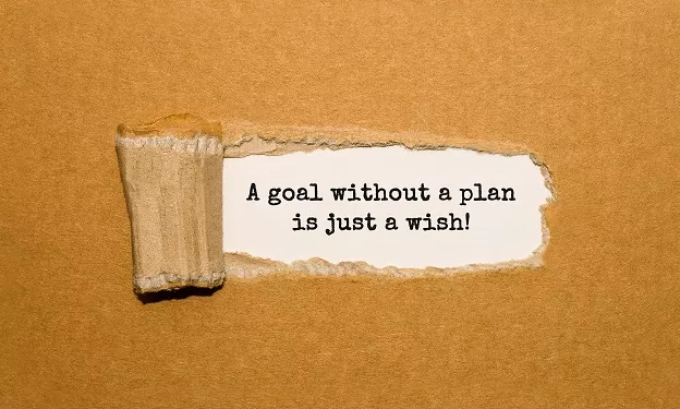 a torn piece of material revealing the quote 'a goal without a plan is just a wish!'