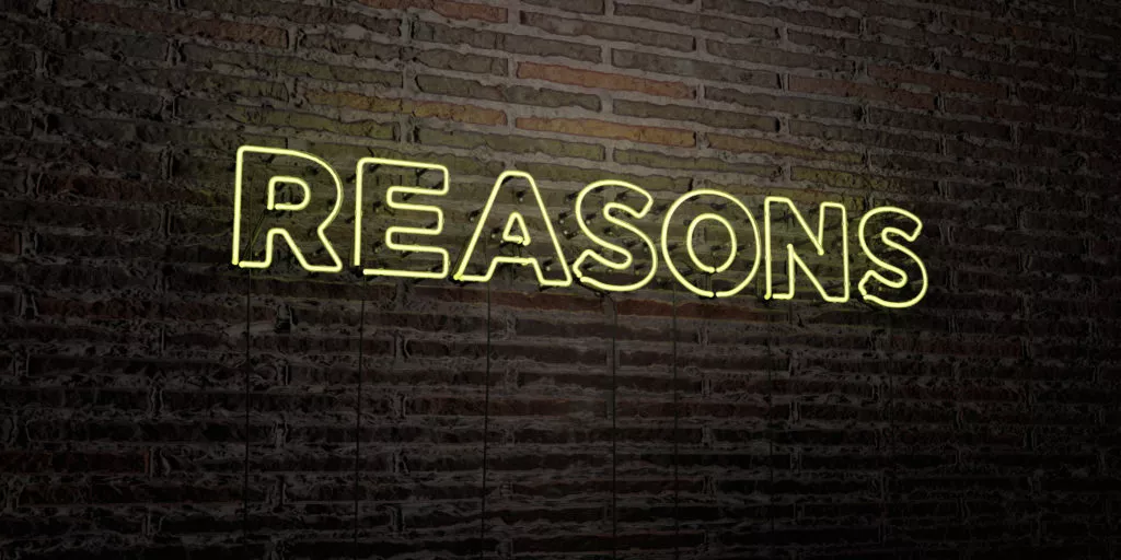 Yellow neon sign that says reasons on a brick wall