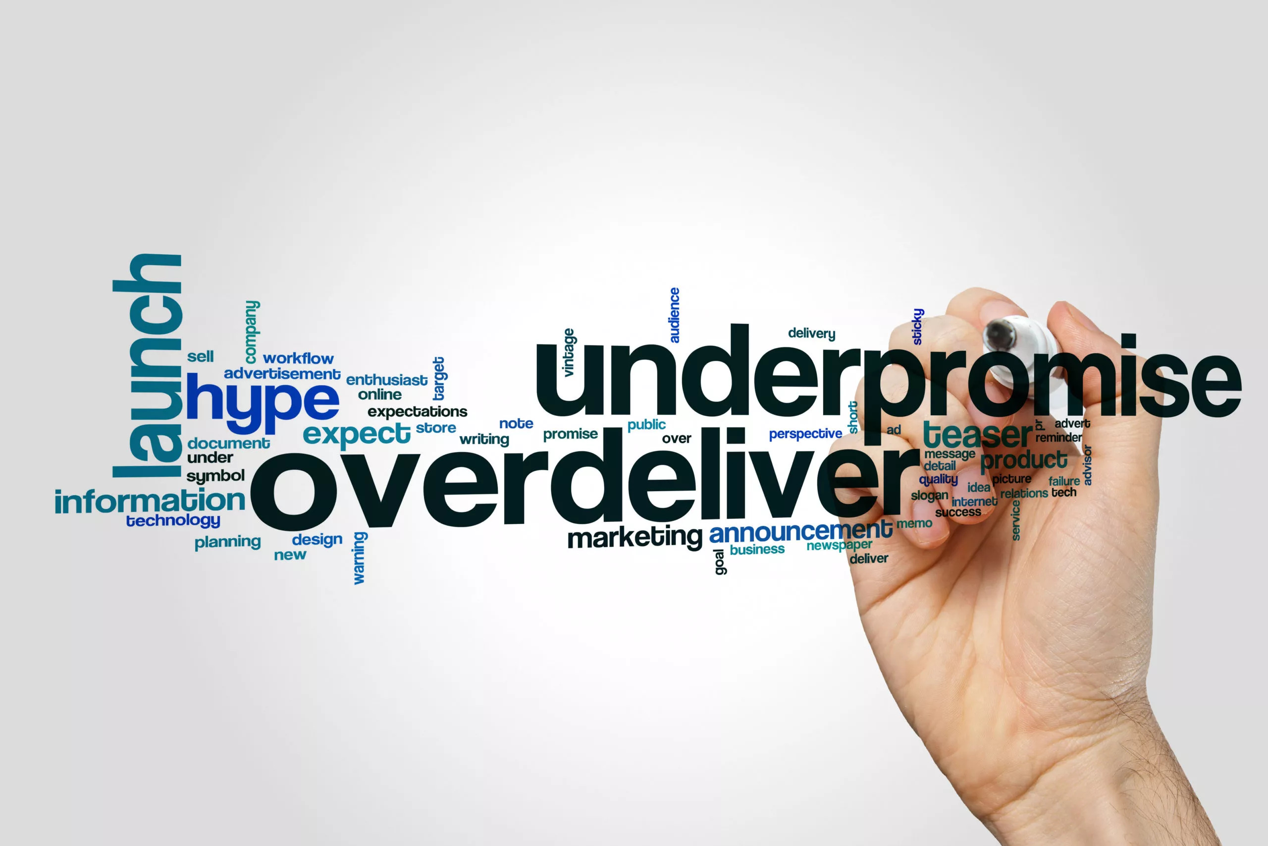 hand writes underpromise overdeliver with a marker