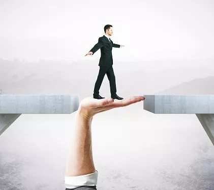 a man in a suit is walking across a bridge held by a hand