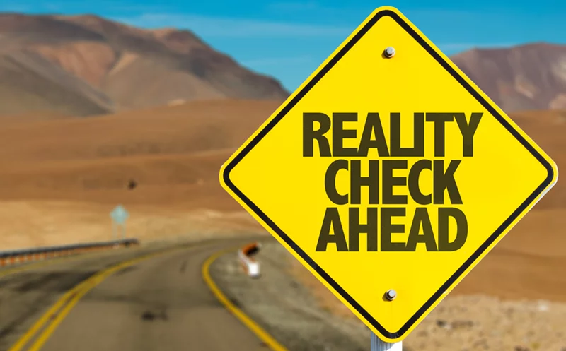 a yellow sign that says reality check ahead