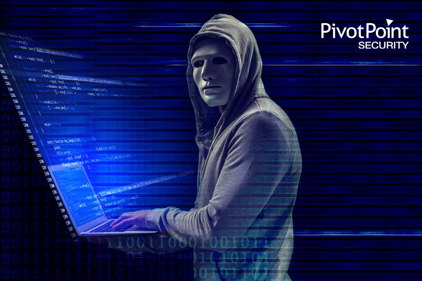 a man wearing a mask is typing on a laptop in front of a pivot point security logo