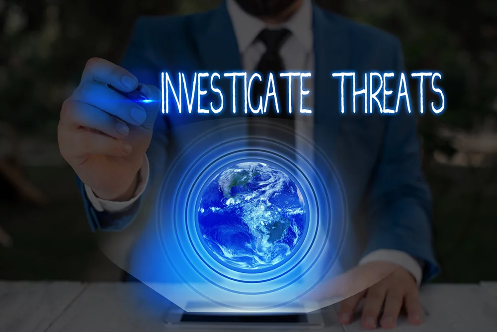 a man in a suit is writing the word investigate threats